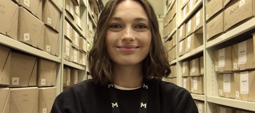 Rebecca Keddie, graduate trainee archive assistant, standing in the archive store.